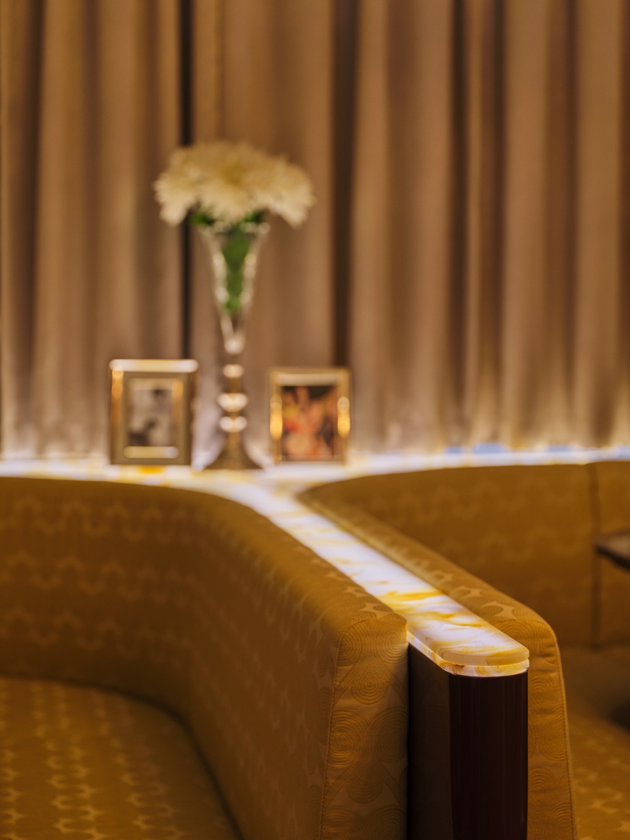 Velvet lounge seating with floral arrangement and soft lighting